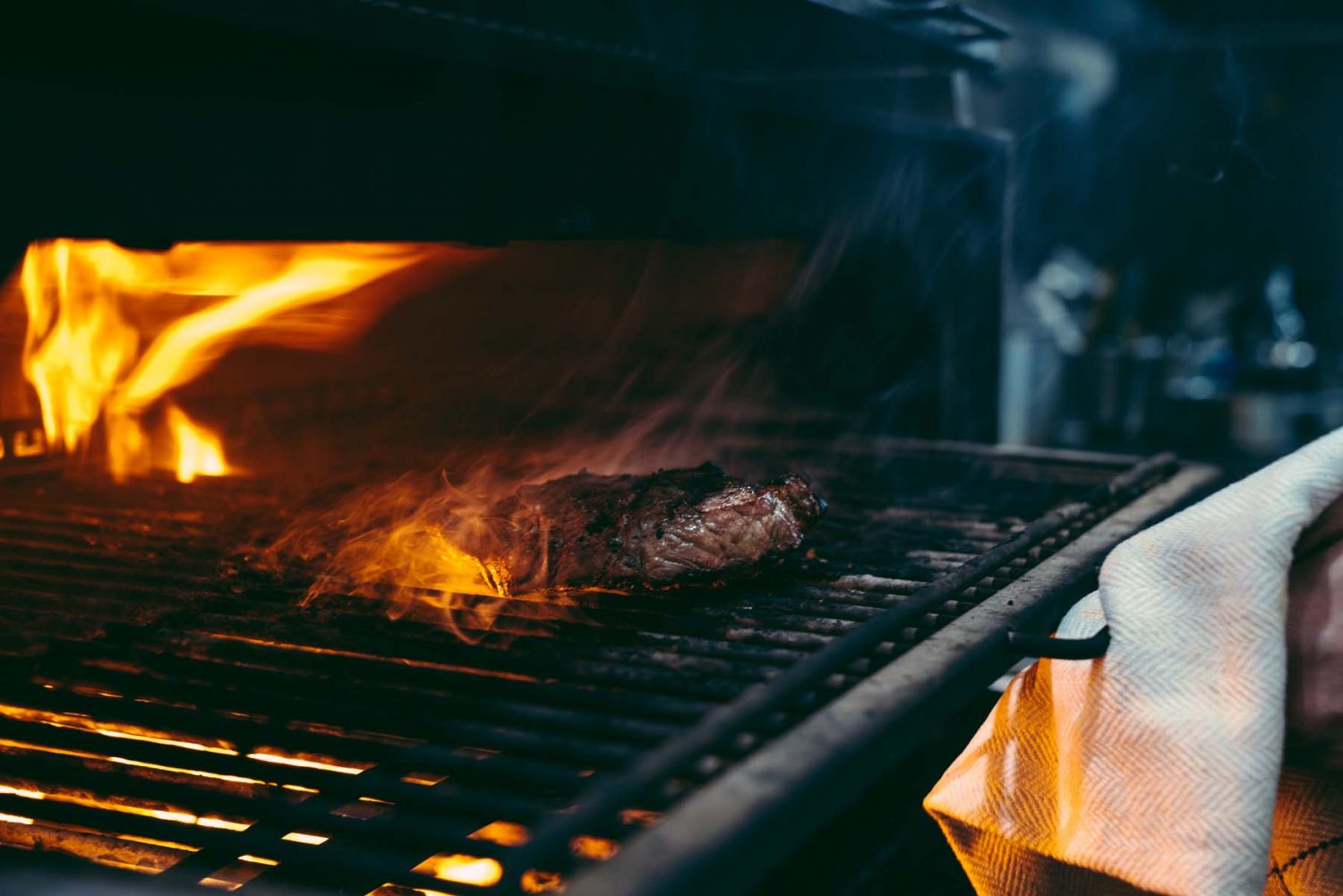 A steak cooking over the Josper grill at The Jones Family Kitchen.